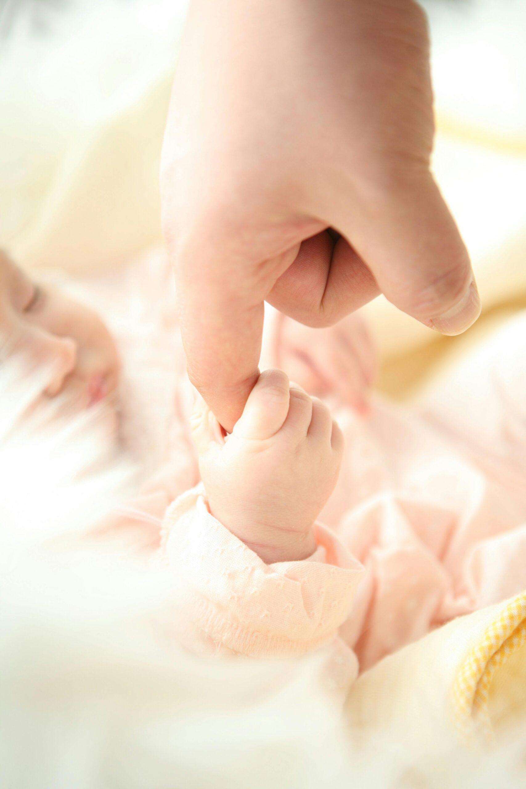 Heartwarming close-up of a baby holding a parent's finger, symbolizing love and connection.